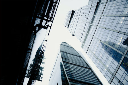 Glass tall blue skyscrapers in the center of a big city, buildings against a cloudy daytime sky