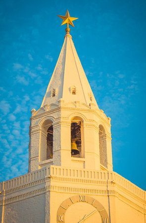 White church tower with golden star, architectural landmark against blue skyの写真素材