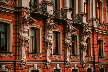 Bas-relief architectural details featuring decorative columns on a red-painted classical building exteriorの写真素材