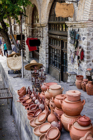 Traditional market displaying terracotta pottery and ceramic dishes on stone counterの写真素材