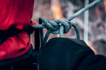 Close-up of climbing rope being tied into a knot with climbing equipmentの写真素材