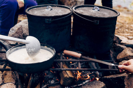 Camping Camp Kitchen, Travelers Cooking Food in Pots on a Campfireの写真素材