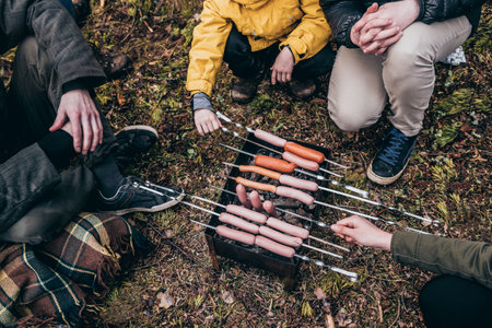People grilling food outdoors while campingの写真素材