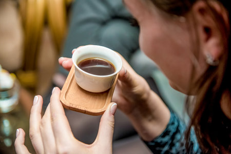 Fragrant tea in a white cup with wooden saucerの写真素材