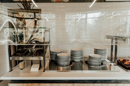Empty buffet station with stacked plates in a restaurant settingの写真素材