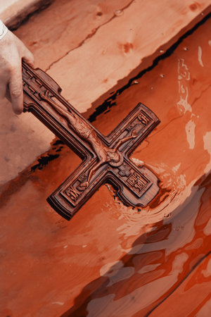 Priest consecrating river water for baptism, holy father holding cross crucifix in hand close upの写真素材