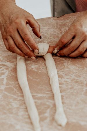 Hands preparing sausage in dough, a delicious dish of dough and meat to be cookedの写真素材