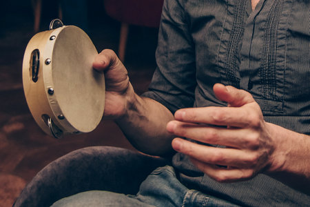 A tambourine player performs at a concert in a nightclub setting