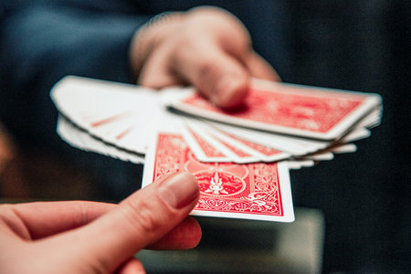 Close up of hands performing card tricks with a deck of playing cardsの写真素材