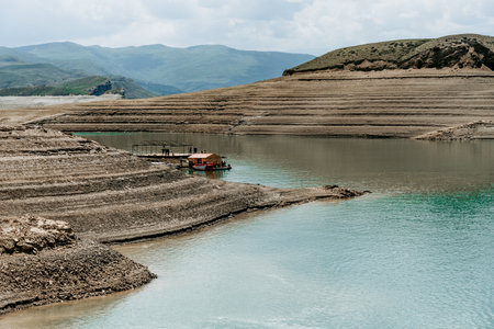 Landscape of blue lake deep in light of the sun in daytime, clouds in sky Dagestan Russia