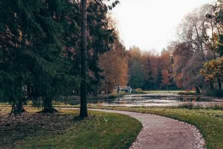 Green city park with walking paths, trail next to a green hedge, cloudy day, Gatchina garden, Saint Petersburg, Russiaの写真素材