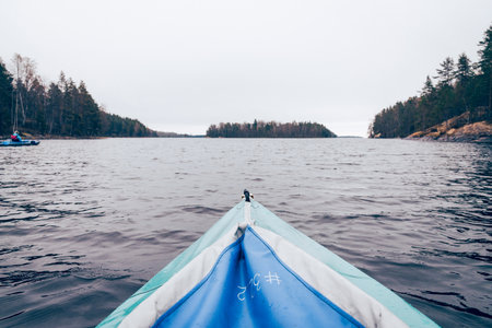 Active holidays on the lake, kayaking on the water, tourism on a cloudy dayの写真素材