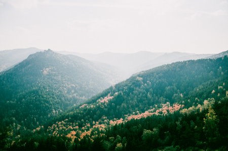 Landscape of snowy Siberia Krasnoyarsk mountains, mountain range in haze in summerの写真素材