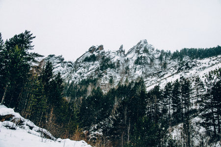 Landscape of Siberia mountains Stolbi, rock peak Takmak range in haze in winter