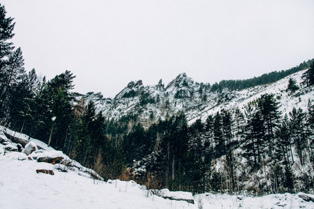 Landscape of Siberia mountains Stolbi, rock peak Takmak range in haze in winterの写真素材