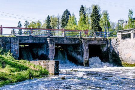 Small hydroelectric power plant in Leningrad region Russia on calm river, summer landscape on sunny dayの写真素材