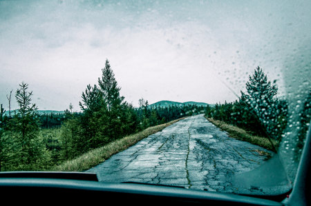 View from the front window of the auto car on the asphalt broken suburban road of the highway on...