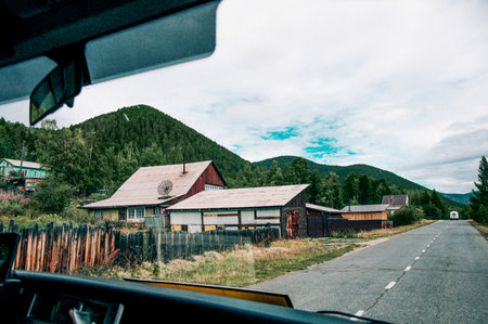 View from the front window of the car on the asphalt suburban road of the highway on cloudy autumn...