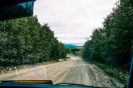 View from the front window of the car on the broken suburban road on cloudy autumn dayの写真素材