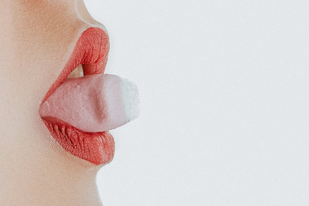 Young beautiful woman eating pink marshmallows, beauty portrait close up face and lipsの写真素材