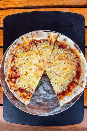 Pizza Margherita cut into chunks on round plate