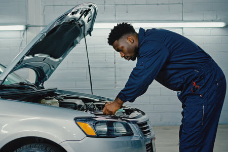 AI Generative man auto mechanic conducts an examination of breakdowns and repairs the transport car in car serviceの素材