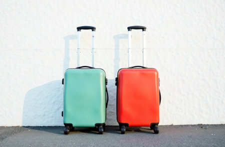 AI Generative Two luggage suitcases on wheels against wall, vacationの素材