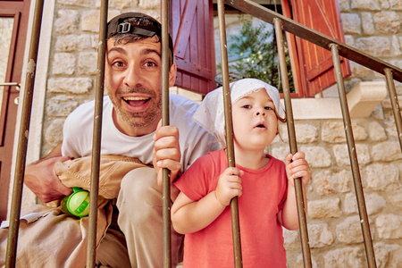 Dad and daughter family fooling around, man and cute little toddler girl walking in city parkの写真素材