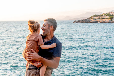 Dad and daughter family hugging, man and cute little toddler girl walking in Adriatic Sea beachの写真素材