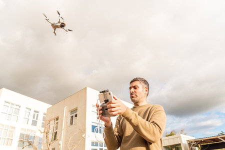Man drone operator catching UAV with hand, photography and videography from the skyの写真素材