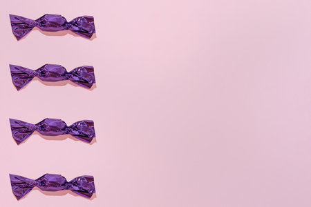 Creative Holiday Pattern with violet Chocolates on Pink Background copy space for textの写真素材