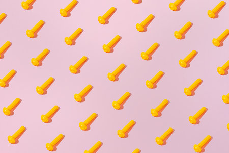 Creative abstract engineering screw pattern flat lay on pastel pink background minimalism