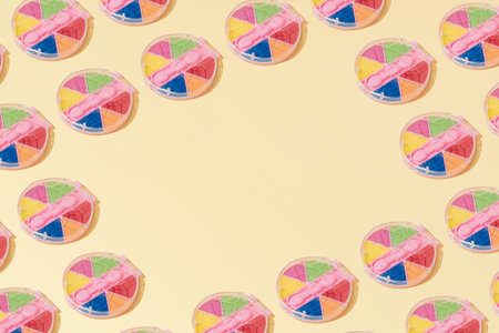 Creative abstract cosmetic makeup eye shadow pattern flat lay on pastel yellow background minimalism...