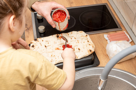 Family man and girl cooking homemade pizza in kitchen, dad and daughter spending time togetherの写真素材