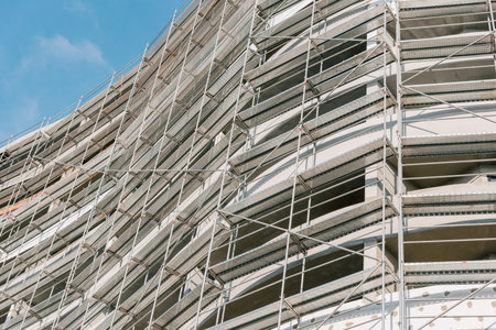 Building under construction with scaffolding, view of the construction site of multistorey frame...