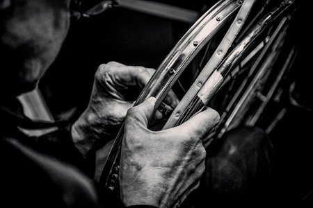 Saint Petersburg, Russia, 7 May 2019, Man repairing broken wheelchair in workshop