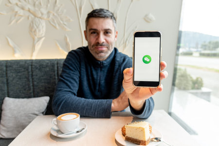 Bar, Montenegro, 9 January 2026, Man calls or writes message through modern WeChat mobile messenger...