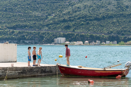 Herceg Novi, Montenegro, 27 April 2025, Children play outside and jump from the pier onto the boatのeditorial素材