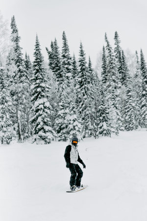 Sheregesh, Russia, 4 January 2021, Snowboarder skier sliding down snowy slope, rider relaxing at ski...