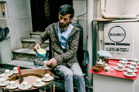 Istanbul, Turkey, 9 May 2018, Man prepares Turkish coffee traditional way in cezve on sand