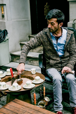 Istanbul, Turkey, 9 May 2018, Man prepares Turkish coffee traditional way in cezve on sand