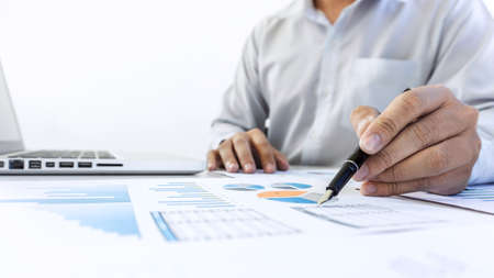 Businessman accountant working audit and calculating expense financial data on graph documents, doing finance in workplace.の写真素材