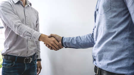 Finishing up a meeting, handshake of two happy business people after contract agreement to become a partner, collaborative teamwork.の写真素材