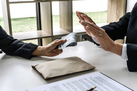 Businessman refuse receive bribe money the form of dollar bills from woman while give success the deal, Bribery and anti-corruption concept.の写真素材