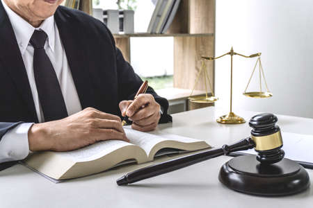 Law, lawyer attorney and justice concept, male lawyer or notary working on a documents and report of...