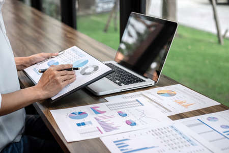 Business woman accountant working audit and calculating expense financial annual financial report balance sheet statement, doing finance making notes on paper checking document.の写真素材
