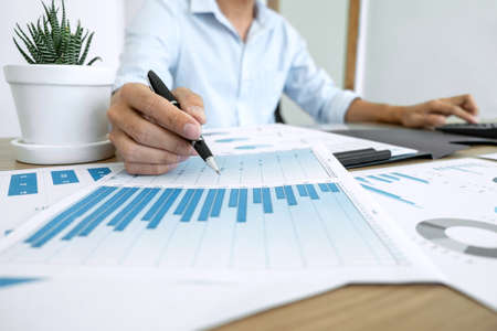 Businessman accountant making working audit and calculating expense financial annual financial report balance sheet statement, doing finance making notes on paper checking inspection.の写真素材
