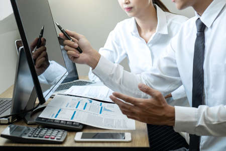 Stock exchange market concept, Team of investment trading or stock brokers having a consultation and analyzing with display screen and pointing on the data presented and deal on a stock exchange.の写真素材