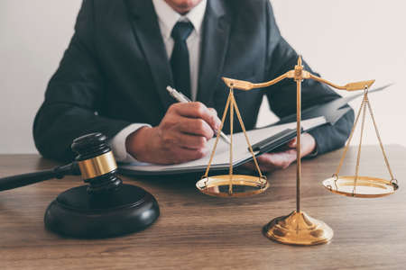 Law, lawyer attorney and justice concept, male lawyer or notary working on a documents and report of the important case in the law firm.の写真素材