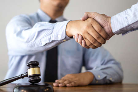Handshake after consultation between a male lawyer and client, giving advice and prosecutions about the regarding real estate.の写真素材